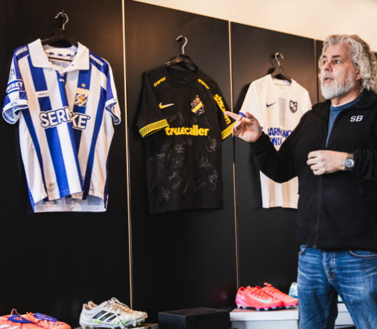 Foto på Brandtowns vd Stephan Burman som visar ett urval av matchtröjor.