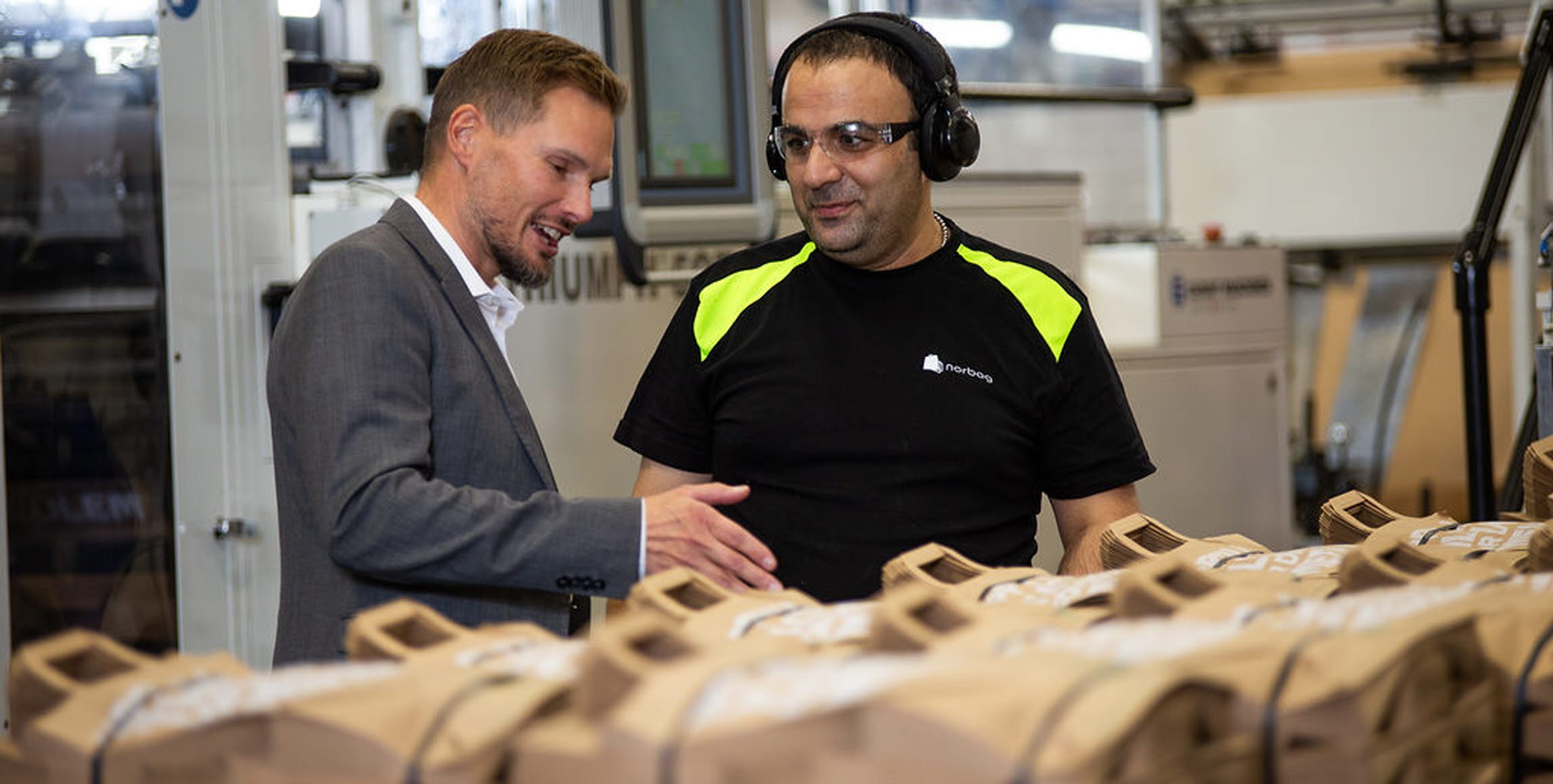 Bild på Torbjörn Rodhe, vd, i samtal med maskinoperatören Issam Ibrahim i Töcksfors.