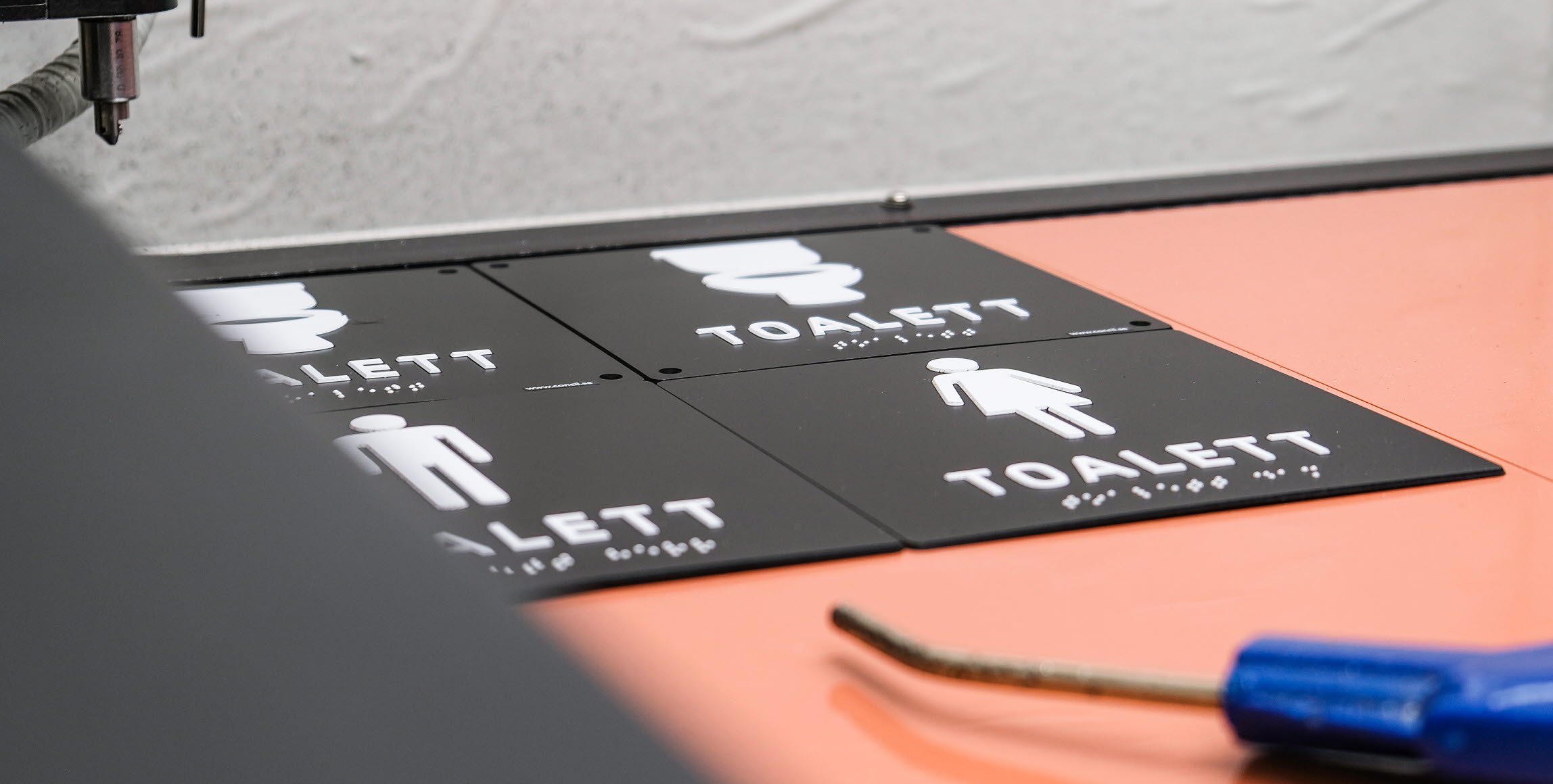 Bild på taktila toalettskyltar.