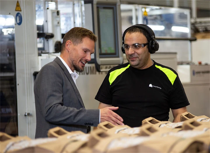 Bild på Torbjörn Rodhe, vd, i samtal med maskinoperatören Issam Ibrahim i Töcksfors.