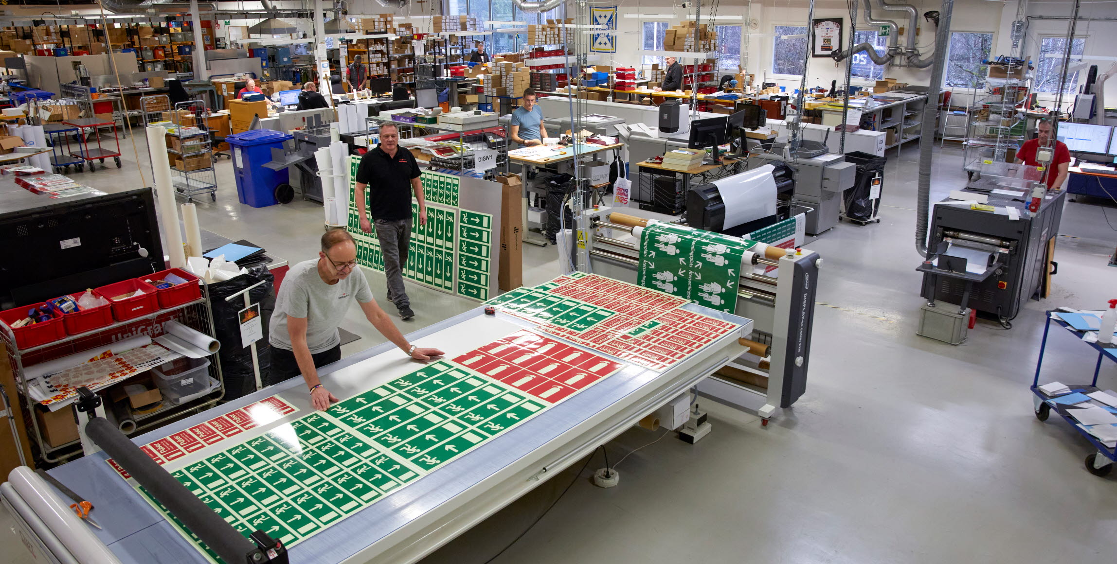 Bild från digitaltrycksavdelningen, med digitaltryckaren Christian Thuresson vid skärbordet.