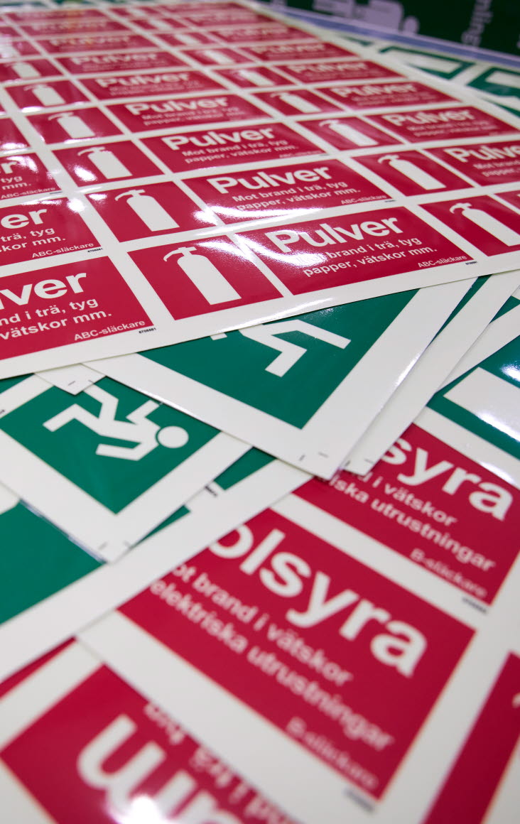 Bild på utrymnings- och brandskyltar, som är några av UniGraphics produkter.