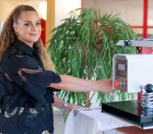 Bild på Alice Norheim, vd på Perma Press, vid en värmepress.