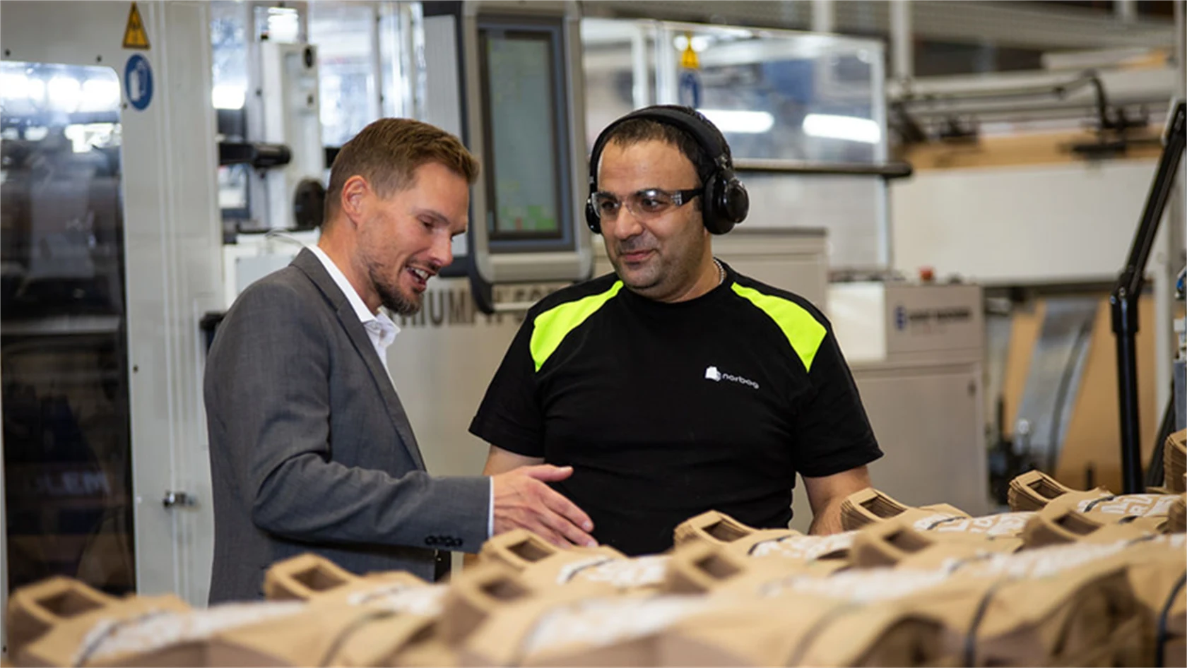 Bild på Torbjörn Rodhe, vd, i samtal med maskinoperatören Issam Ibrahim i Töcksfors.