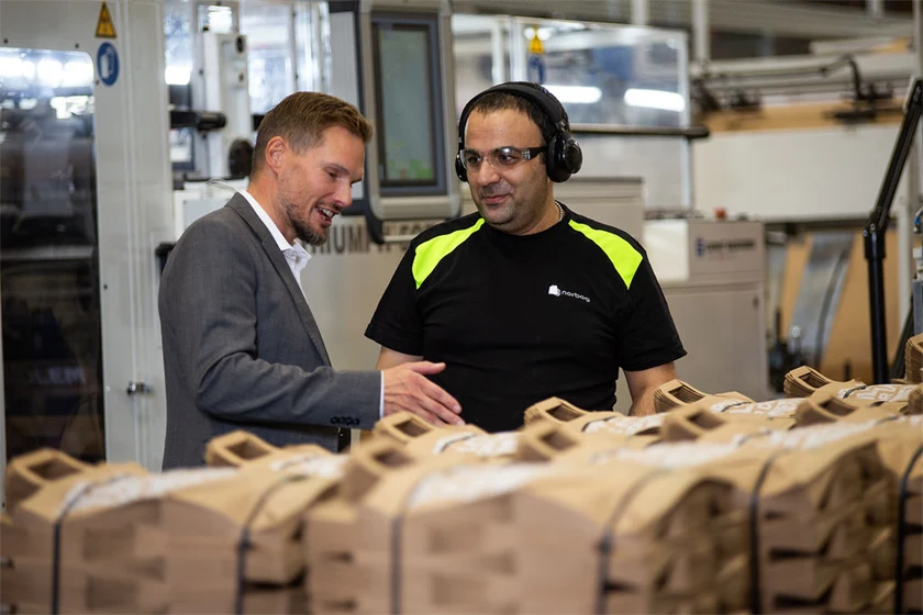 Bild på Torbjörn Rodhe, vd, i samtal med maskinoperatören Issam Ibrahim i Töcksfors.